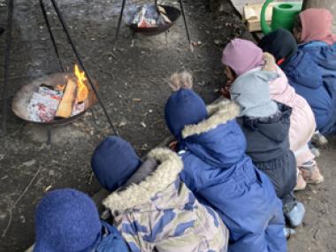 Børnene holder øje med bålet og venter på deres frokost.